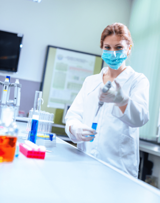Lab technician holding beaker 